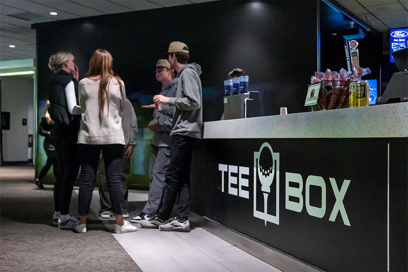A young player at Tee Box practicing their swing with the best golf simulators.